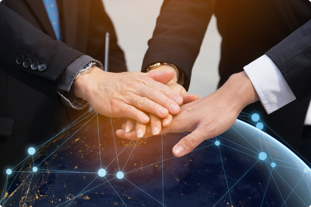 地球儀とビジネスマンの手を重ねる握手のイメージ、国際的な信頼関係を象徴