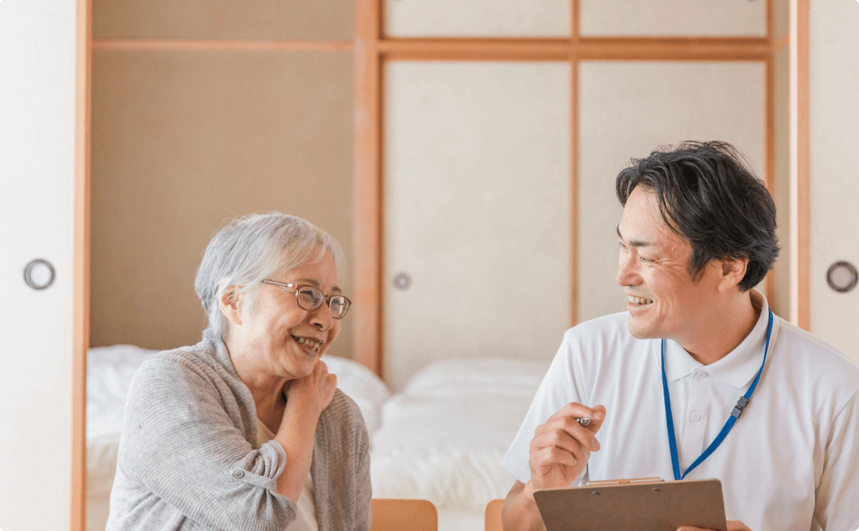 介護職員が利用者と笑顔で会話している様子
